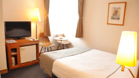 部屋の広さ14～16平米。ベッドはダブルサイズ200cm×140cm。テレビが設置された机はスライドテーブル付きのため、PC作業に最適です。