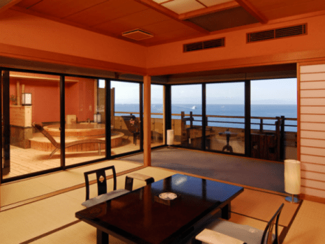 駿河湾に面した源泉掛流しの露天風呂付「最上階・特別室：桜桃花」。露天風呂周辺にリラクゼーションのスペースを設けた贅沢なつくり。