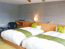 和モダンツインベッドタイプのお部屋。窓の外には半露天の信楽焼露天風呂が駿河湾が広がる。