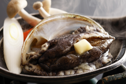 【アワビ鉄板焼き】バター×磯の風味が広がる、温泉旅定番の一品。