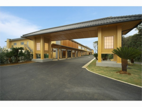 大きな長屋門が目印。手前が日帰り温泉、奥にホテルが佇む。