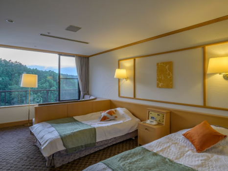 別館「ことほぎ」のツインベッドルームにはソファをご用意。景色を見ながらお寛ぎのひとときを。