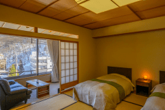 ゆったり12.5畳の本間にはツインベッド。 広縁には大きなソファを備えております。