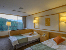 別館「ことほぎ」のツインベッドルームにはソファをご用意。景色を見ながらお寛ぎのひとときを。