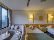 「ことほぎ」のツインベッドルームは22平米の広さ。伊香保の山々を見ながら、リラックスして