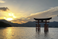 夕日が海を黄金色に染める中、穏やかな瀬戸内海に嚴島神社の大鳥居が幻想的に浮かぶ