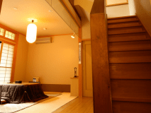 1階の居間、2階の寝室と2部屋分の広さを持つメゾネット客室。写真の1階居間には冬季間こたつをご用意。