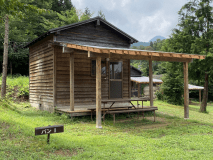 バンガロー１の外観です。建物前のバーベキュースペースまで屋根があるのでタープ無しでも大丈夫です。向かってすぐ右側が駐車スペースになります。