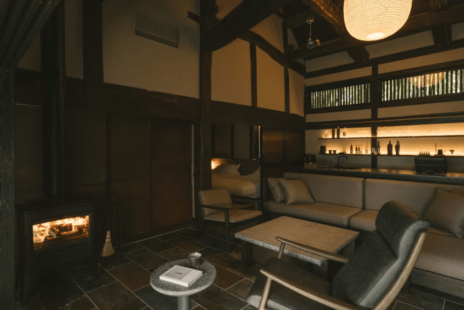 【１日一組様 特別棟】暖炉に火が灯り温かみを増したリビング。揺れる炎をゆっくり眺める静かなひとときをお愉しみください