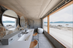 【エクスクルーシブスイートヴィラ・クイーンベッドメゾネット】ビーチと同じ目線の岩壁を設えたバスルームです