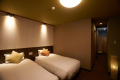 【特別室】ベッドルーム例。落ち着いた色調とシックな彩りが心にくつろぎを与える