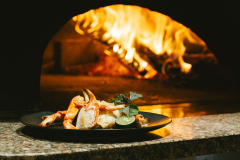 ［薪窯で焼く蟹］高温で一気に焼き上げる艸花ならではの焼き蟹。［一例］