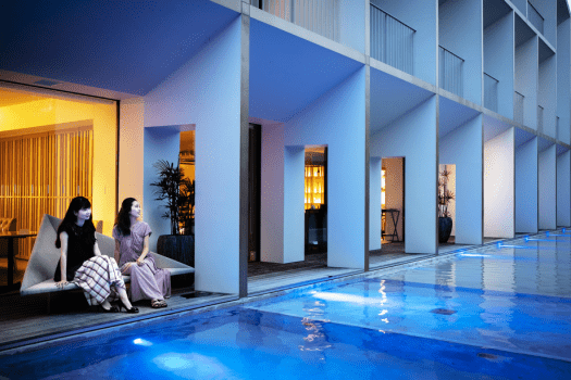【屋外温水プール】 日が沈んだら夜のプールサイドへ。青く揺らめく水面が幻想的な空間を演出します。