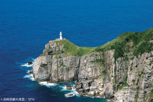 九州本土で最も遅い時間に夕陽が沈む場所=大瀬崎灯台。海に突き出た断崖絶壁の上に建つ白い灯台は、青い海とのコントラストが美しく、「日本の灯台50選」に選ばれています。3700カンデラ光度でおよそ22km先まで照らし、近海を航行する船の道しるべとなっています。 九州本土で最も遅い時間に夕陽が沈む場所=大瀬崎灯台。海に突き出た断崖絶壁の上に建つ白い灯台は、青い海とのコントラストが美しく、「日本の灯台50選」に選ばれています。3700カンデラ光度でおよそ22km先まで照らし、近海を航行する船の道しるべとなっています。