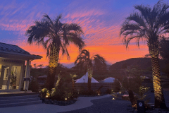 夕焼けに染まった管理棟とグランピング施設