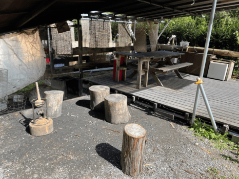 デッキ前には、屋根付きの竈門と焚き火ができるスペースがあり、デッキ上には4名がけのテーブルと専用の給湯付きの流しがあります。