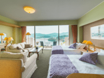 最上階にある特別フロア「華真珠」にある、6畳の和室・ツインベッドの洋室・バルコニーがついた合計61平米のお部屋です。
＜華真珠＞の名の通り、室内のしつらえは上品で瀟洒。
窓の外には伊勢の海が広がり、最上階ならではの絶景が楽しめます。