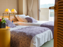 6畳の和室にツインベッドの洋室、バルコニーがついた合計61平米の和洋室。
和室のくつろぎとベッドの快適さ、両方の良さを取り入れました。窓の外には伊勢の海が広がり、壮大な景色が楽しめます。