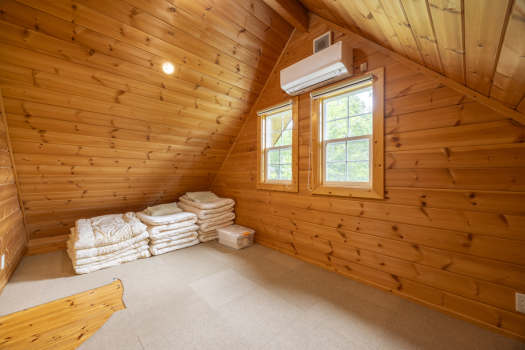 【グループ】ロフトから繋がる10帖の寝室。ログハウスならではの三角屋根の優しい雰囲気。