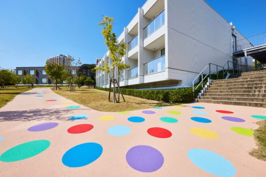 点在する宿泊棟をつなぐポップでカラフルな遊歩道