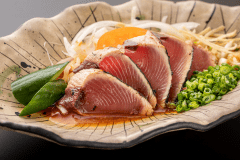＜絶品！カツオのたたき＞香ばしく炙った肉厚な身は、たっぷりの薬味＆オリジナルのたれとともにどうぞ♪