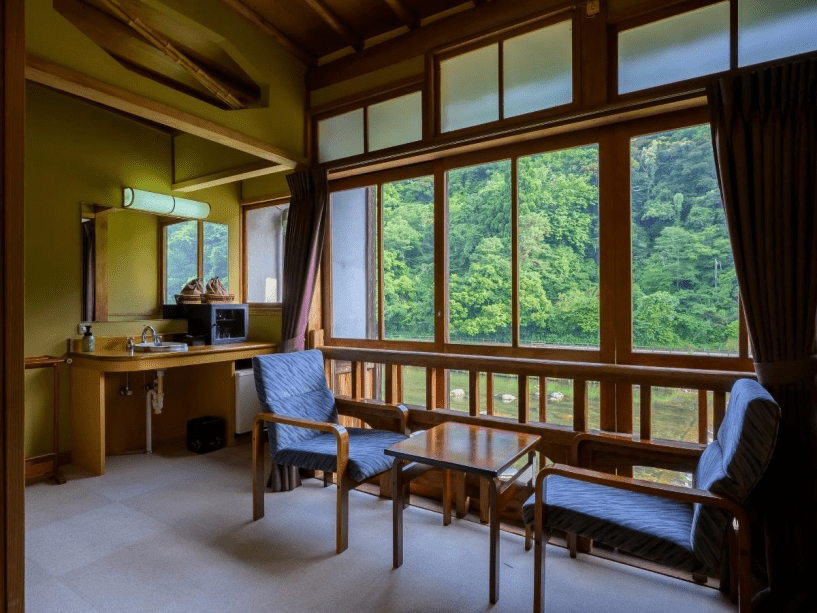 広縁から川を眺め、山々はまるで絵画のように時間が止まったような静かな景色です【桜の間】