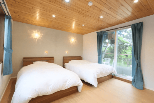 木目をあしらった落ち着きある寝室はセミダブルベッドを二つご用意しています。