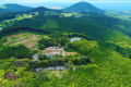 【施設上空】山だけでなく、海も眺められる風光明媚な地。美しい緑に心も癒されるひと時を