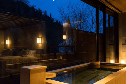 夕暮れ時、ジャパニーズスイートの半露天風呂。白銀の湯を湛える贅沢で静かなひと時を。