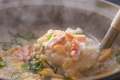 【冬のお料理】カニ雑炊は、カニの旨味たっぷりの出汁にご飯と卵が絡む、心温まる贅沢な締めの一杯（一例）