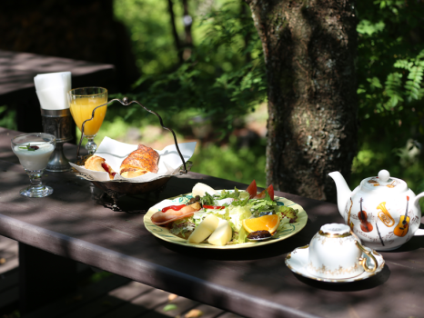 朝食は焼き立てパンと野菜プレート。夏季は緑に囲まれたテラス席でお召し上がりいただけます。