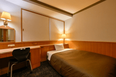 【スタンダードシングルルーム】15平米、禁煙／喫煙：ベッドは幅140cmのダブルサイズでゆっくりお休みいただけます。冷蔵庫あり。WiFiに加えて有線LANもご利用いただけます