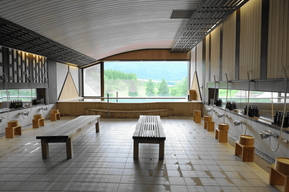 標高1261ｍの禿岳（カムロダケ）を一望する大浴場。露天のような大きな窓から雄大な眺めを