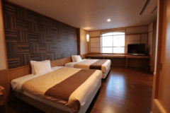 松花亭 特別室｢暁｣　　
170cm幅のクイーンサイズベッドを2台完備。上質なシモンズ製ベッドが、旅先でも変わらぬ快眠をお届けします。ご家族やご友人とのご利用にも最適です。