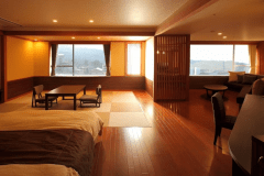 松花亭 和洋室｢山あかり｣　　 
伊香保温泉街と、その奥に望む草津白根山を一望できる和洋室。仕切りなく広がるコーナーリビングと畳部分、シモンズ製ベッド2台が織りなす上質な空間が魅力です。寛ぎと眺望を兼ね備えた贅沢なひとときをご堪能ください。