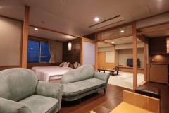 松花亭 特別室｢寛｣　　
広々とした和洋室タイプの特別室は、角部屋ならではの開放感が魅力。窓の外には伊香保温泉街の風情ある景色と、遠くに草津白根山を望む、心ほどける眺めが広がります。