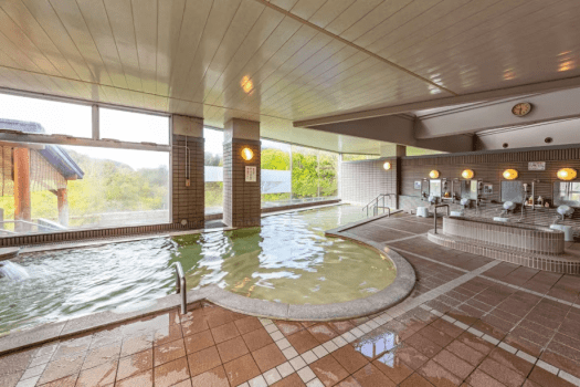 【大浴場】広々とした浴室から望む暑寒連峰の美しい稜線。 心地よい湯浴みをお愉しみくださいませ。