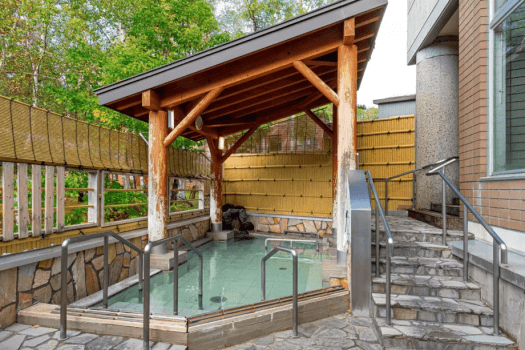 【露天風呂】遠く暑寒連峰が眺められます。一度に6～7人がお入りいただける広さです。