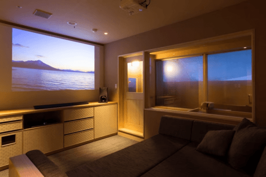 【温泉＆シアター付客室60平米（山側）】映像の各シーンにマッチした臨場感を味わえる音響効果『5.1chサラウンド』を採用し、90インチの大画面で迫力ある映像と音響をお愉しみいただけます。