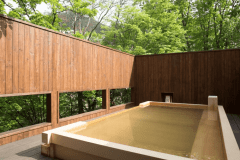 【川乃湯／檜造りの露天風呂】定山渓温泉の泉源でもある豊平川を眺めながら、ゆったりと開放的な湯浴みをお愉しみいただけます。心地よい檜の香りが深い安らぎへと誘います。