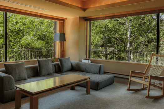 【スイート110平米／リビングスペース】窓から白樺林を望み、自然と一体化したような心地よさがある特別室でございます。