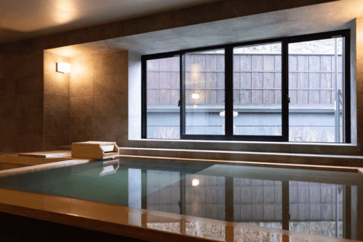 Mountain-facing guest room with hot spring and reclining bath "Renju" (160 square meters) / A spacious guest room with hot spring bath filled with water straight from the source. To allow you to enjoy the hot spring for longer, a reclining bath just 6 cm deep has been installed next to the regular bathtub.