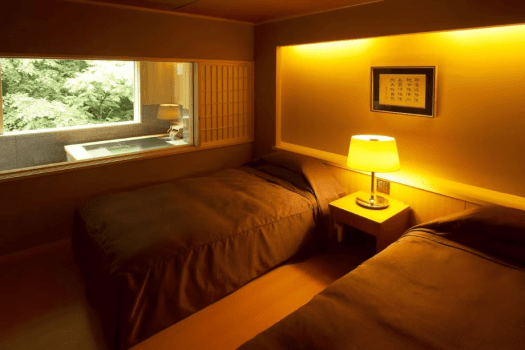 [Example of a Japanese-Western room with a panoramic bath (75 square meters)] This is the bedroom. In the back is the panoramic bath with natural hot spring water.