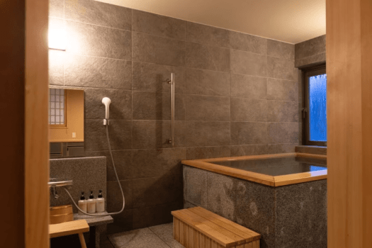 [Example of a Deluxe Twin Room with Hot Spring (60 square meters/Universal Design)] Handrails are installed next to the bathtub.