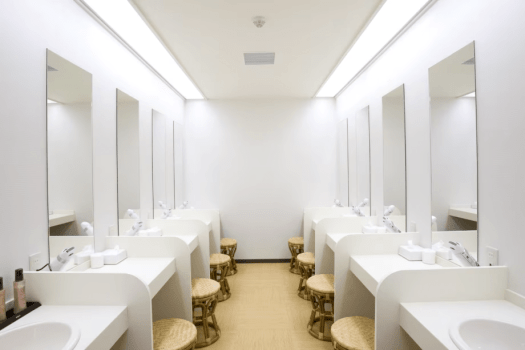 【パウダールーム】清潔で明るい空間に、お一人おひとりのスペースをゆったり確保しています。