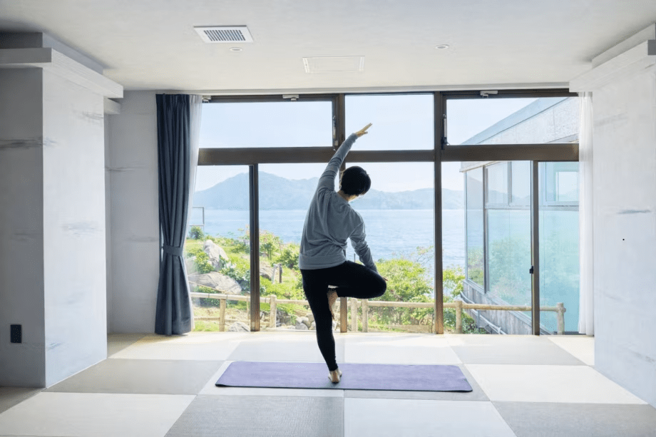 【ヨガ】窓の向こうの海と空が、まるでステージのように広がる。朝日を浴びながらポーズを取ると、自然と自分の境界が溶けていくような没入感。