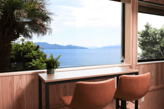 【悠久の季・オーシャンスイート／インナーテラス】地下1階とは思えない、海を見晴らす高台の絶景。部屋の窓辺に配置したハイテーブルでお酒などを飲みながら優雅な時をお過ごしくださいませ。