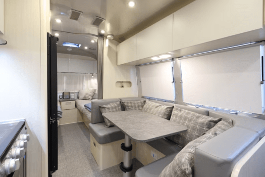 【エアストリーム】入口横のソファとテーブルが配されたラウンジスペースでは、海を眺めながらのリラックスタイムを。ソファはベッドに展開可能で、柔軟な使い方ができます。