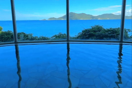 【悠久の湯／オーシャンビュー展望大浴場】肌をやさしく包む美肌の湯と、海を望む静かな湯処。陽光に輝く青い海も、雨に霞む穏やかな水平線も、すべてが心をほどく景色に。訪れるたびに、時がゆるやかにほどけていくような癒しのひとときを。