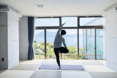 【ヨガ】窓の向こうの海と空が、まるでステージのように広がる。朝日を浴びながらポーズを取ると、自然と自分の境界が溶けていくような没入感。